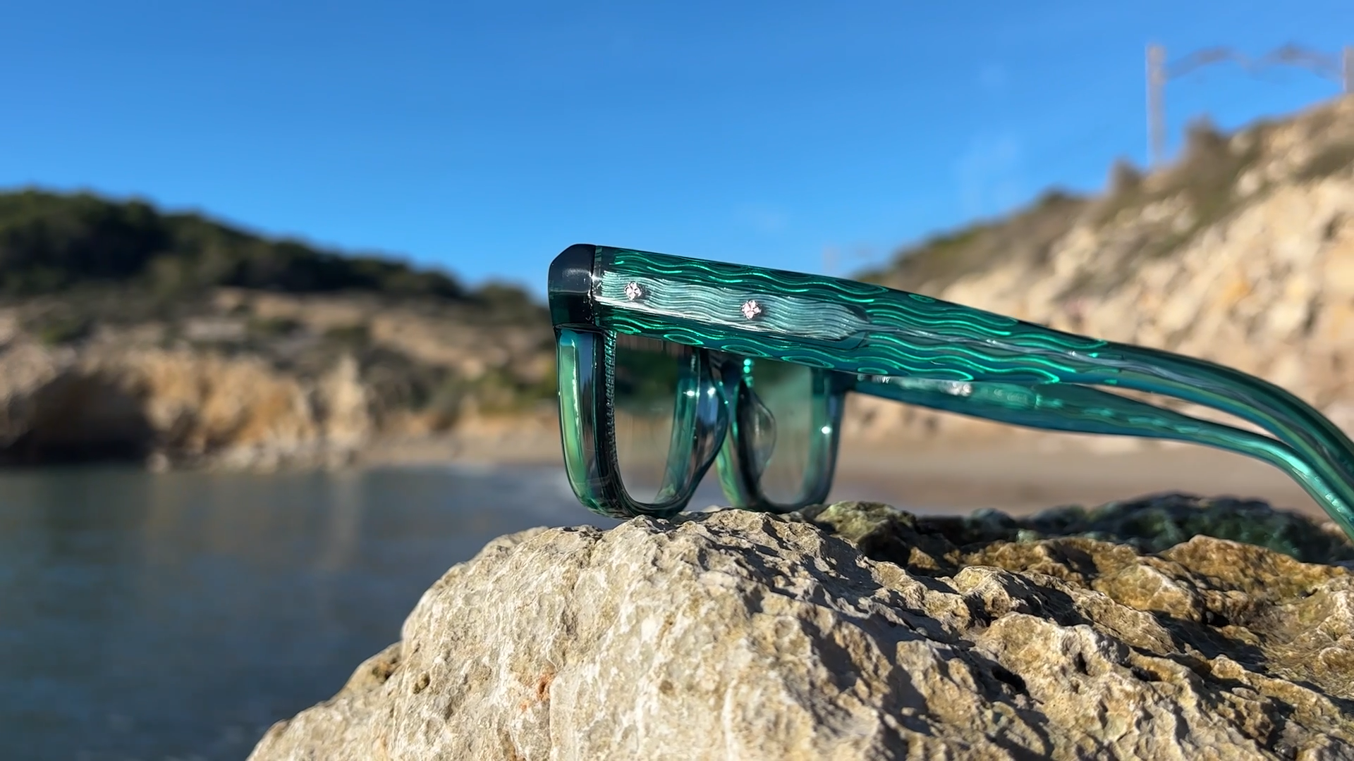 Green Barcelunettes Vagues acetate frame on Mediterranean rocks in sunlight